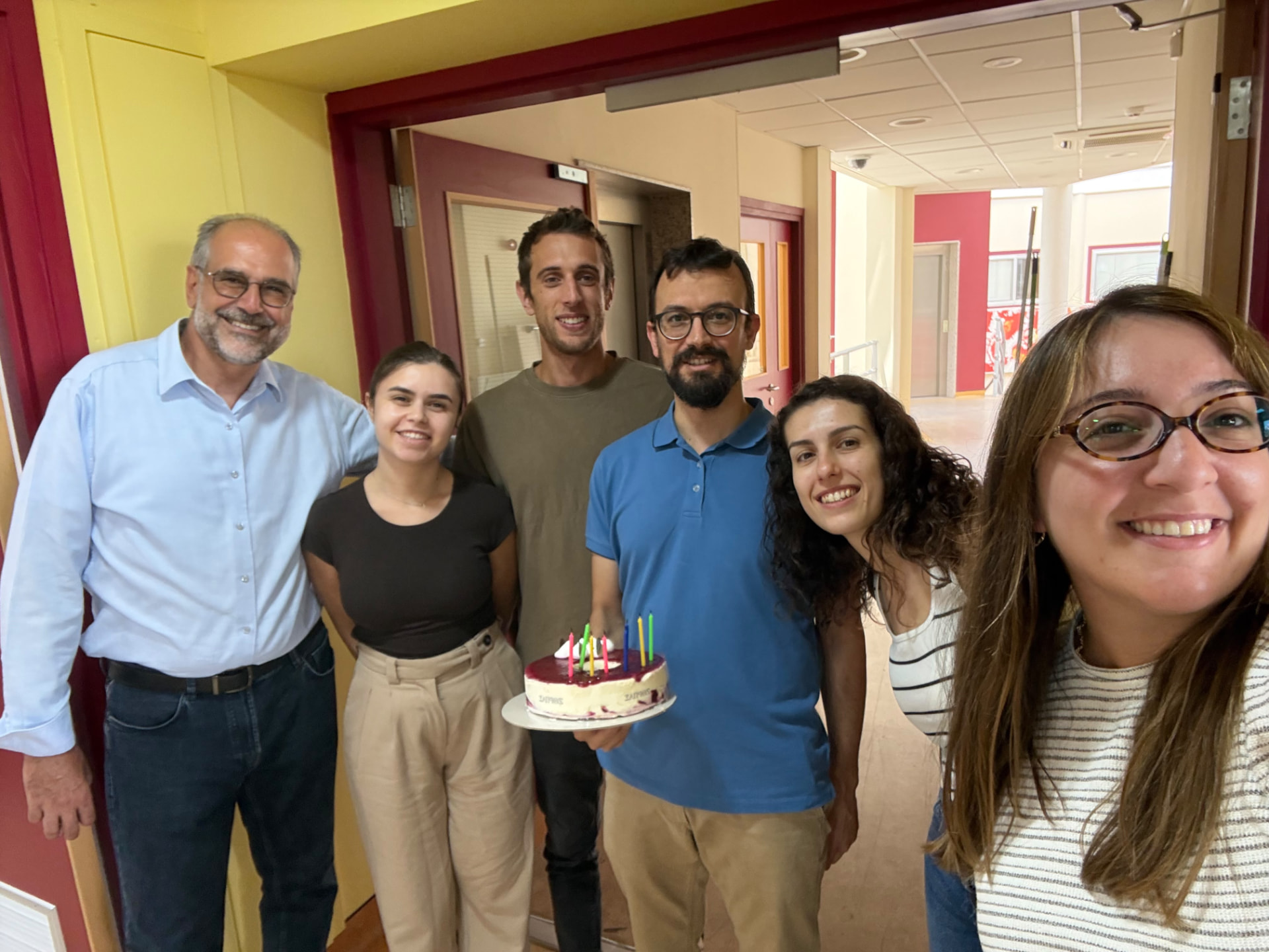 CMIT team members sharing a celebration with a cake